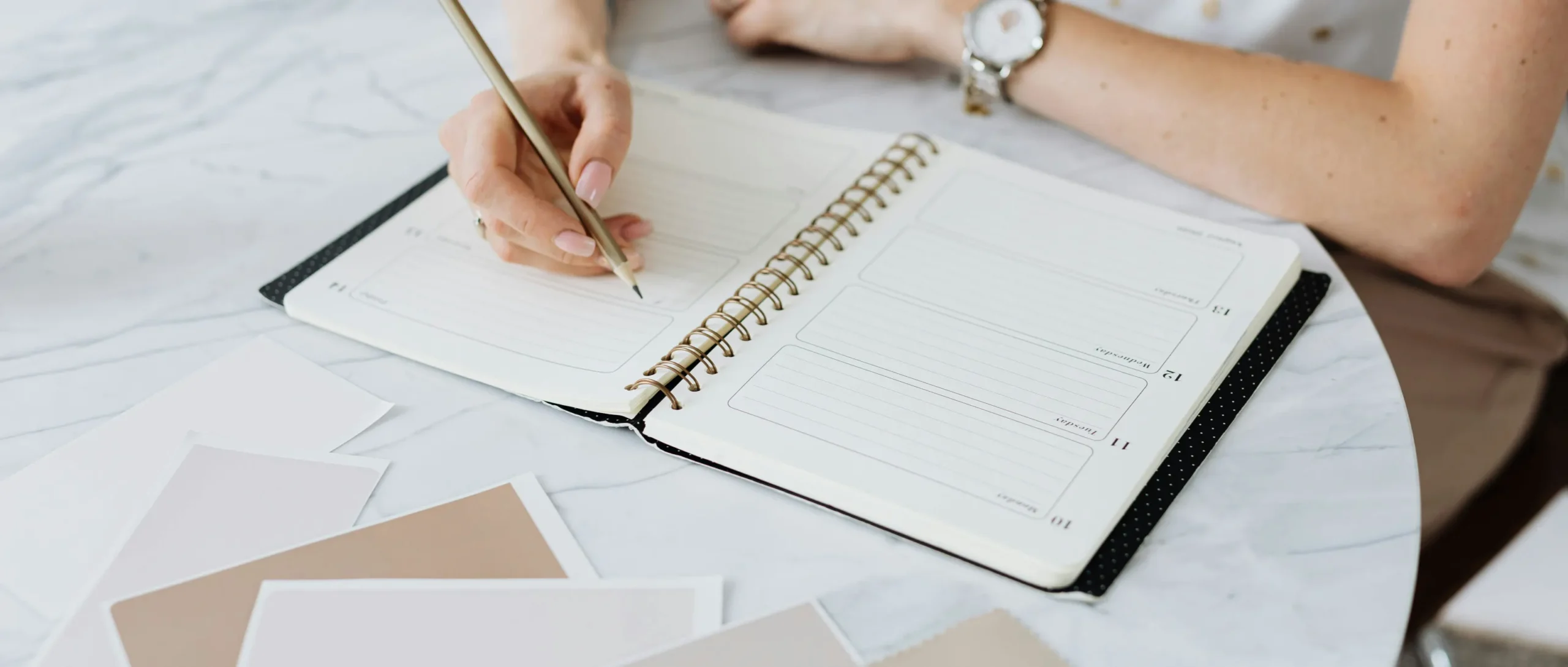 Kuva naisesta kirjoittamassa muistikirjaan